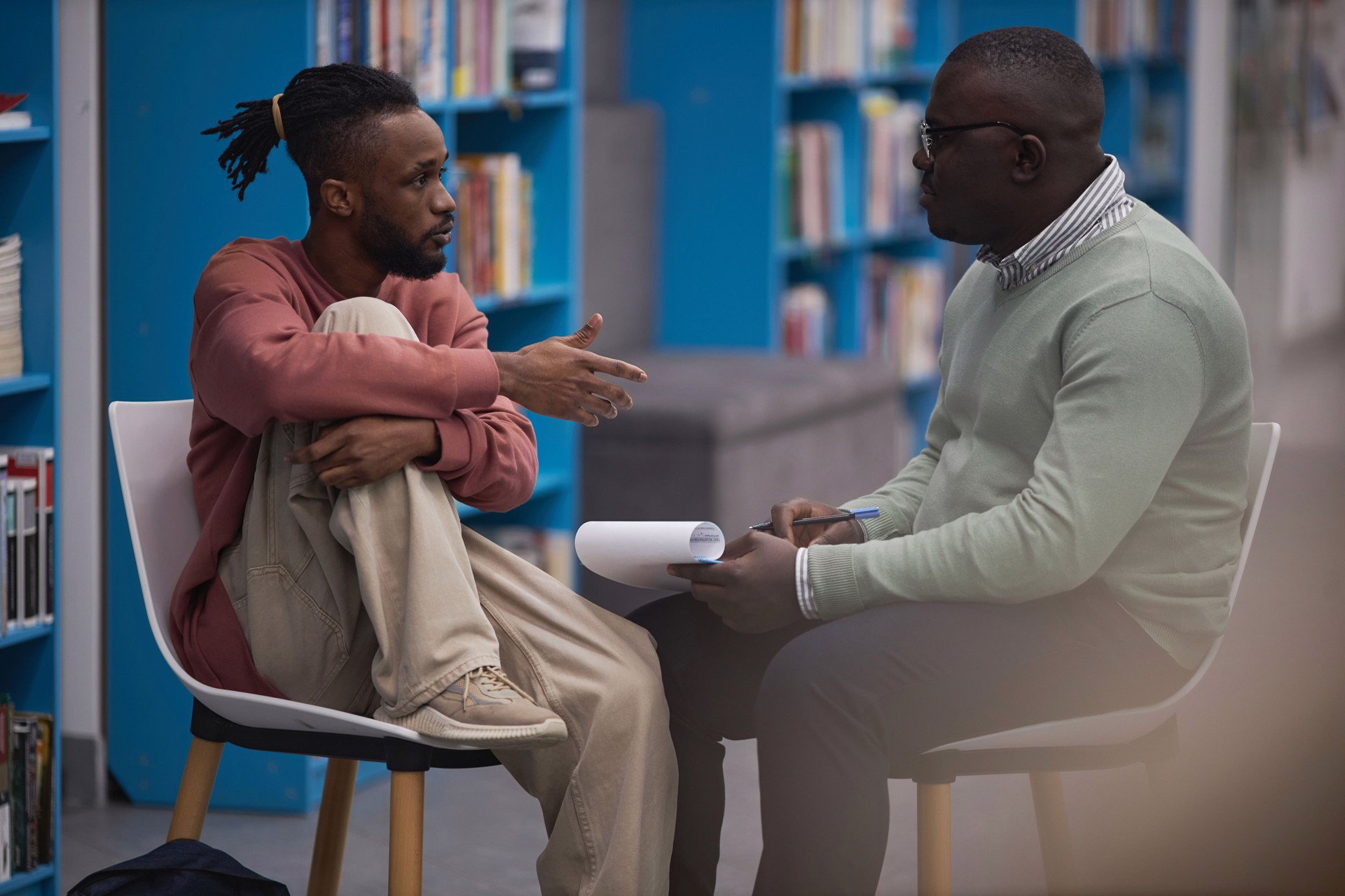 Black student talking to mental health therapist or guidance counselor